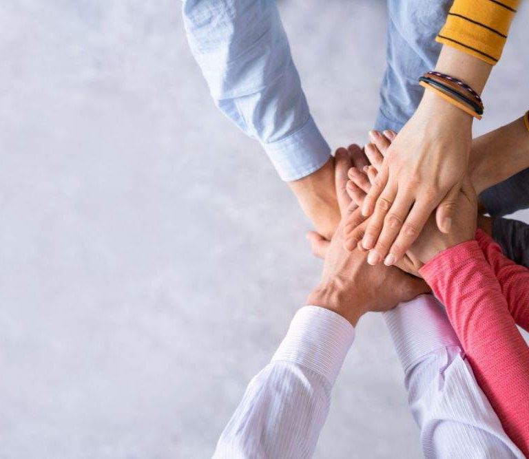 pessoas colocam as mãos umas sobre as outras em sinal de comprometimento simpolizando a retanção de talentos nas empresas