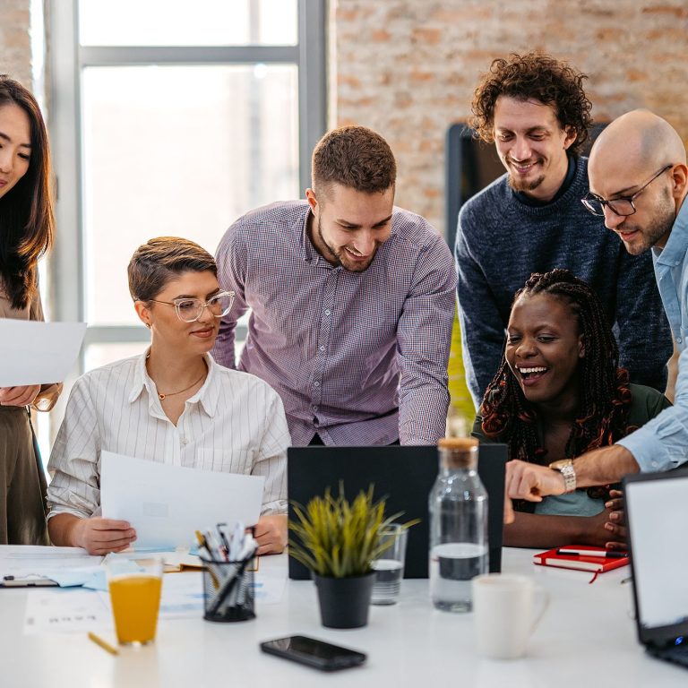 Grupos de pessoas em volta da mesa de trabalho.