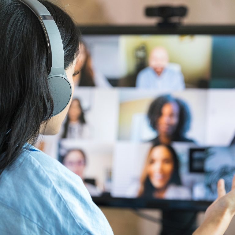 Mulher utilizando computador em vídeo chamada.