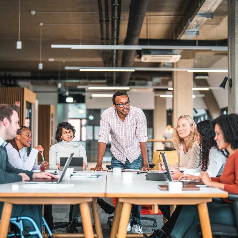 Time de uma empresa em volta de uma mesa.