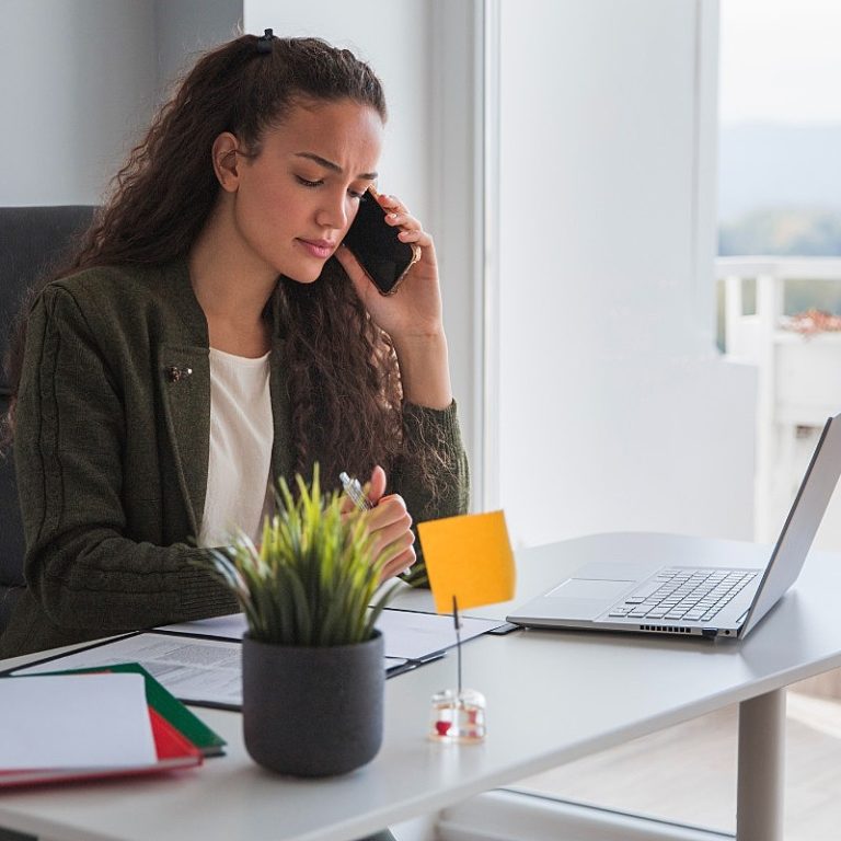 executiva falando ao telefone mostra irritação ao ter problemas com os documentos para admissão de colaboradores