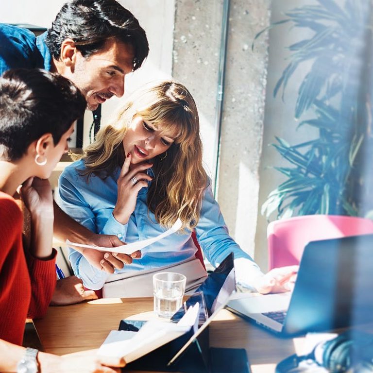grupo de trabalho com três pessoas conversa sobre a matriz de responsabilidades