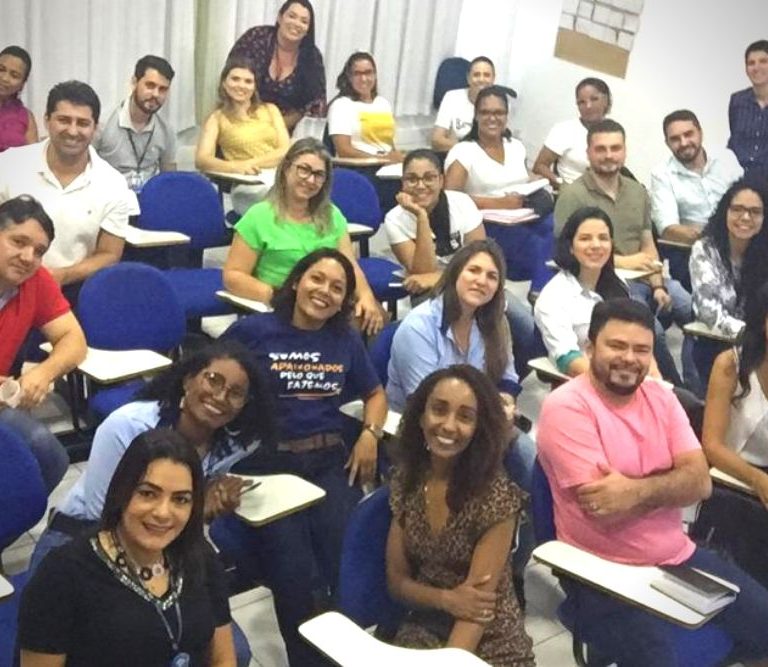 Equipe de 30 líderes da Farmácia Mônica reunidos para uma foto durante o final de uma atividade de RH