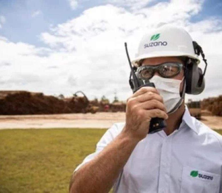 criamos um programa persolizado de lideranças para suzano no maranhão. Na imagem, um funcionário da Suzano fala a um radio comunicador diante de um campo aberto